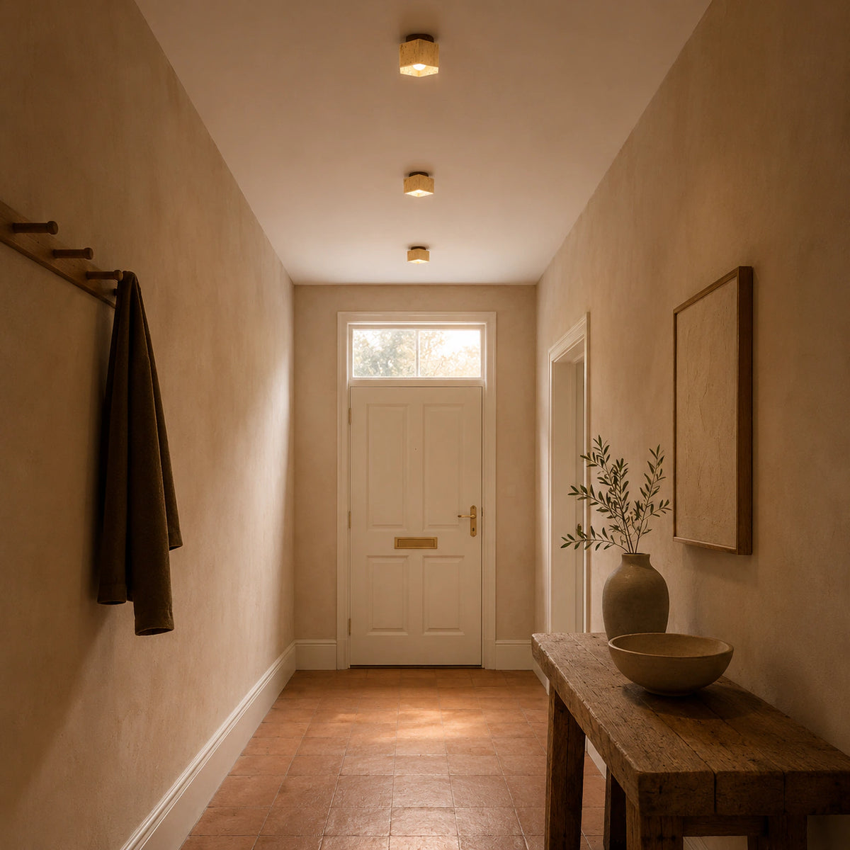 Travertine cube ceiling light with a walnut collar lighting a plastered hallway