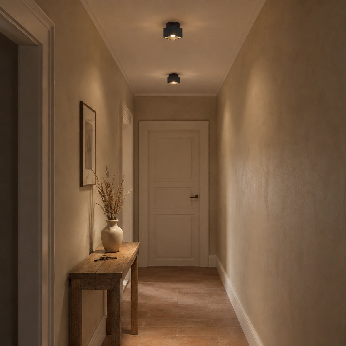 Black travertine cube ceiling light lighting a plastered hallway