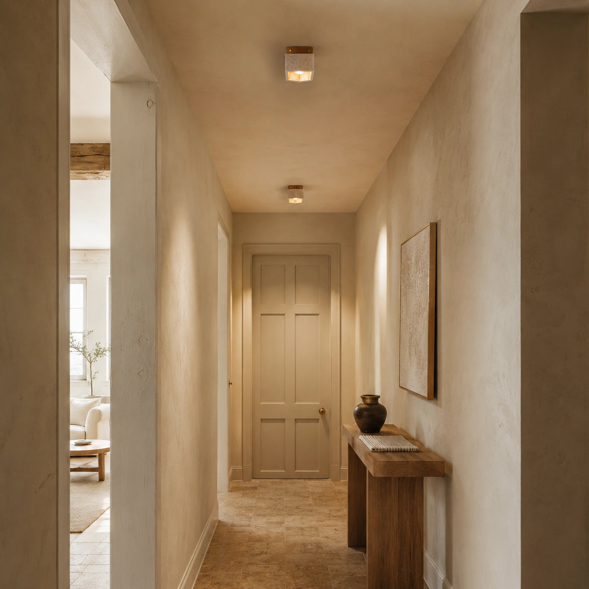 Travertine cube ceiling light with an oak collar lighting a plastered hallway