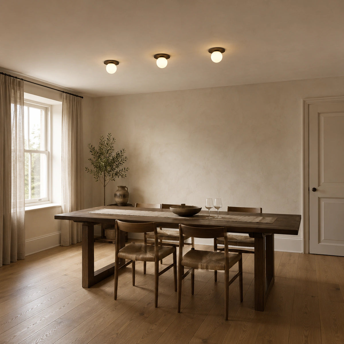 Black travertine disc ceiling light lighting a minimalist dining room