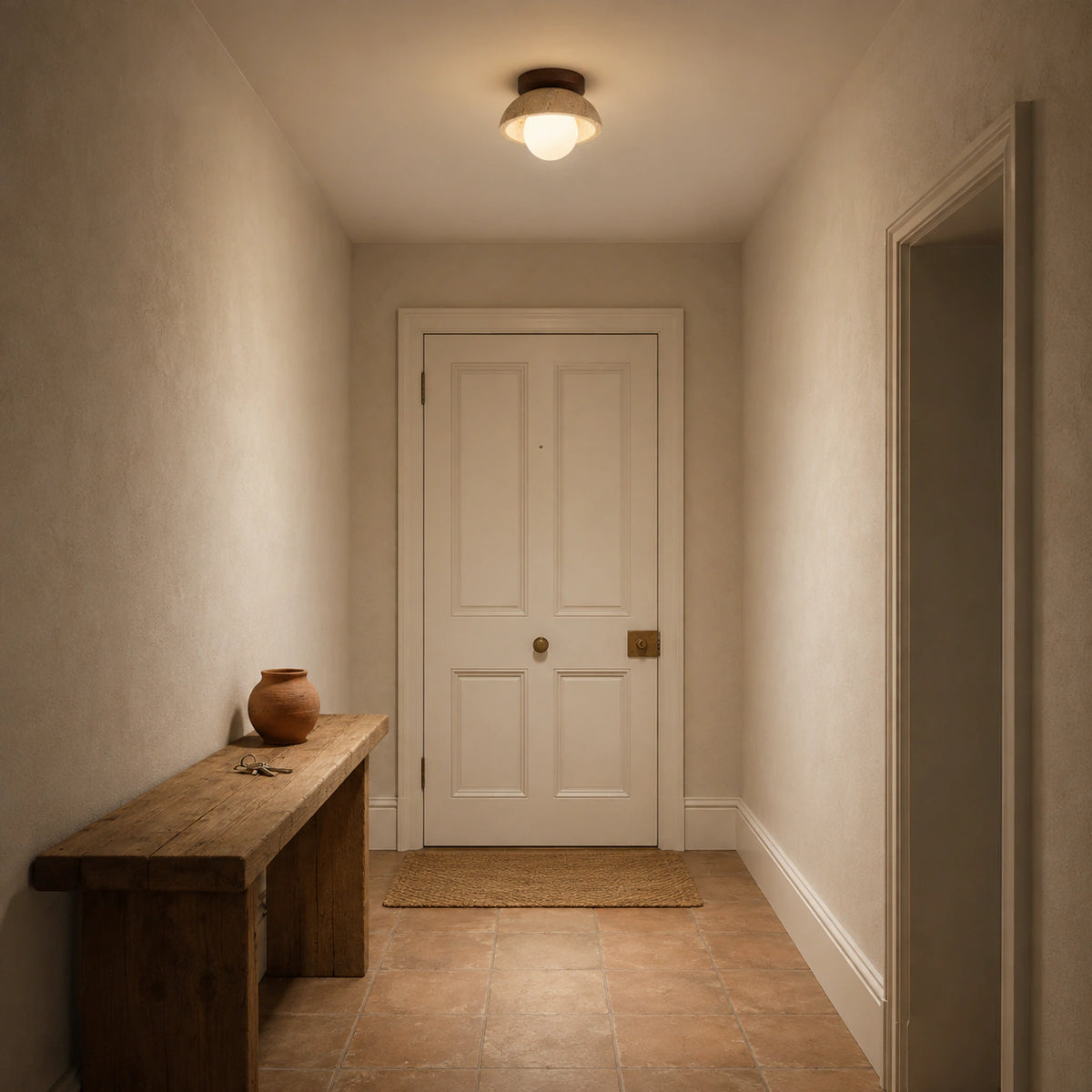 Travertine dome ceiling light with a walnut collar lighting a plastered hallway