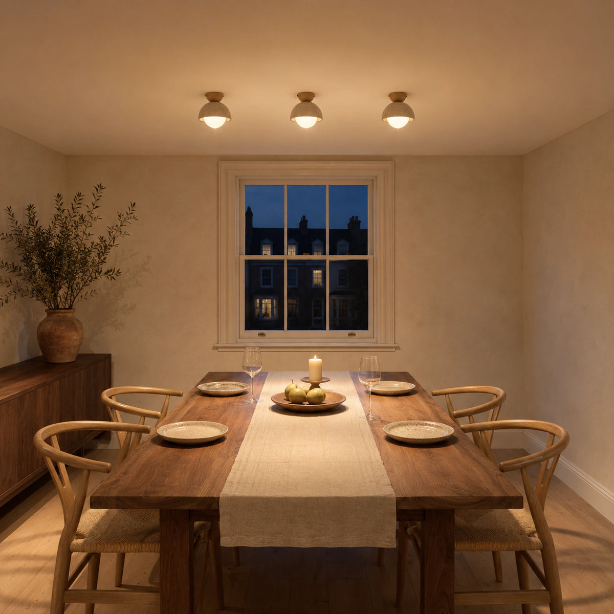 Deep travertine dome ceiling light above a minimalist dining table