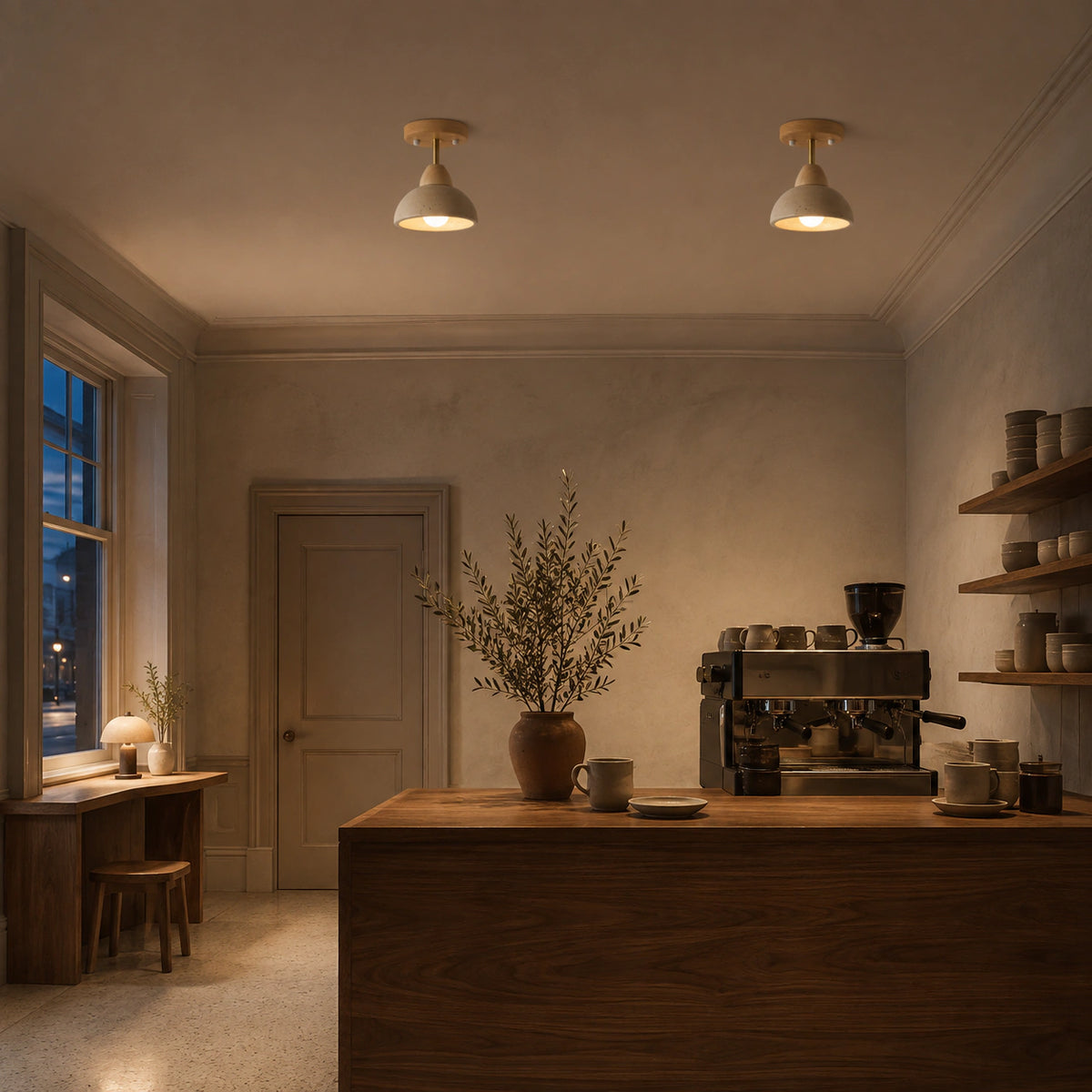 Adjustable travertine dome spotlight over the counter of a warm minimalist cafe