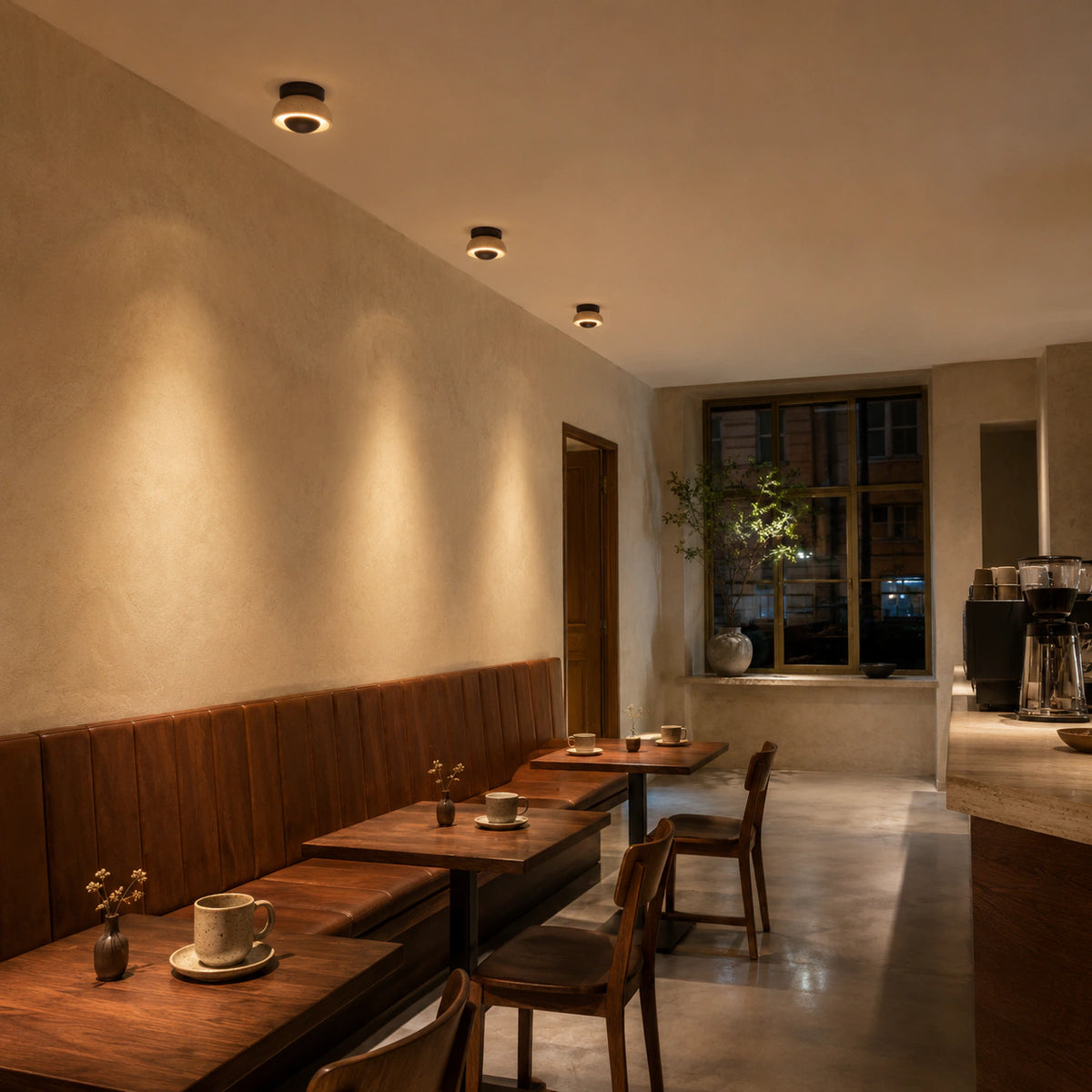 Travertine ceiling light with a walnut reflector in a warm minimalist cafe