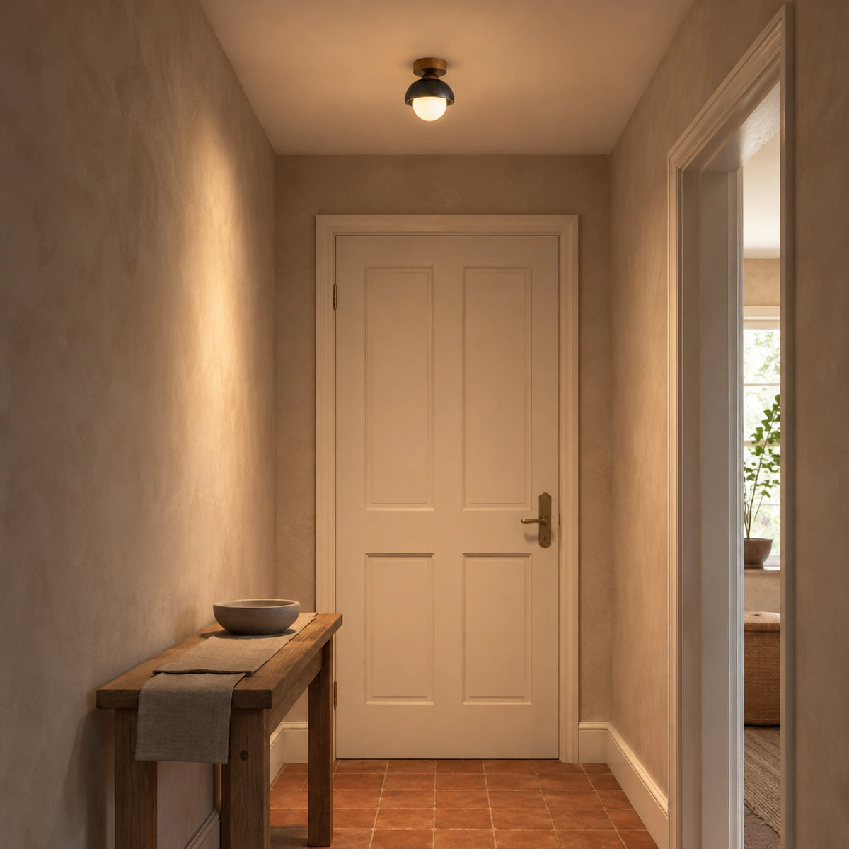 Black travertine dome ceiling light lighting a plastered hallway