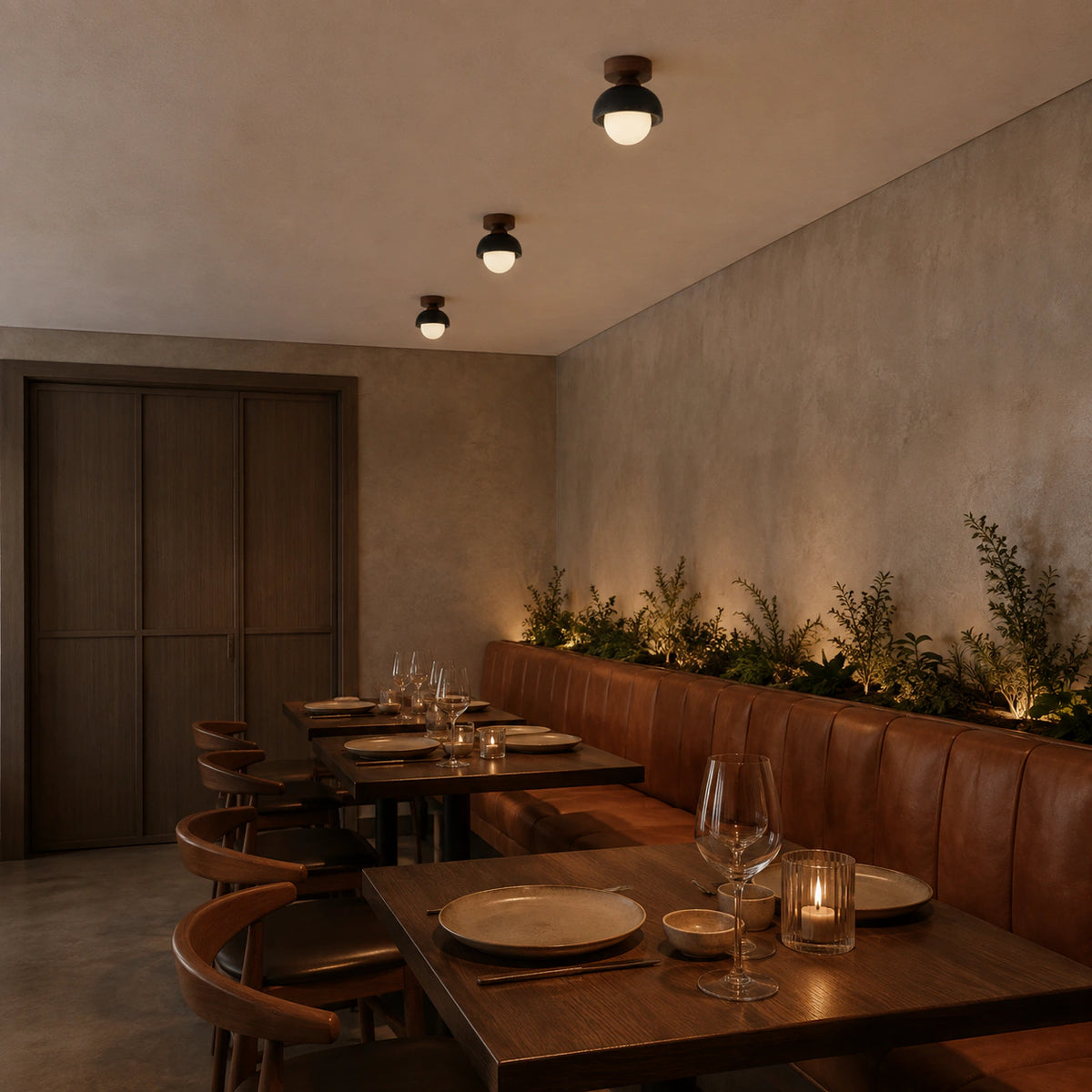 Black travertine dome ceiling light above leather banquette seating in a restaurant