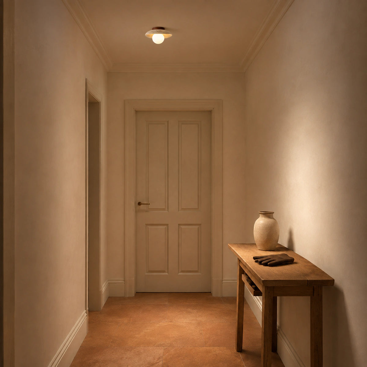 Wide travertine dish ceiling light lighting a plastered hallway