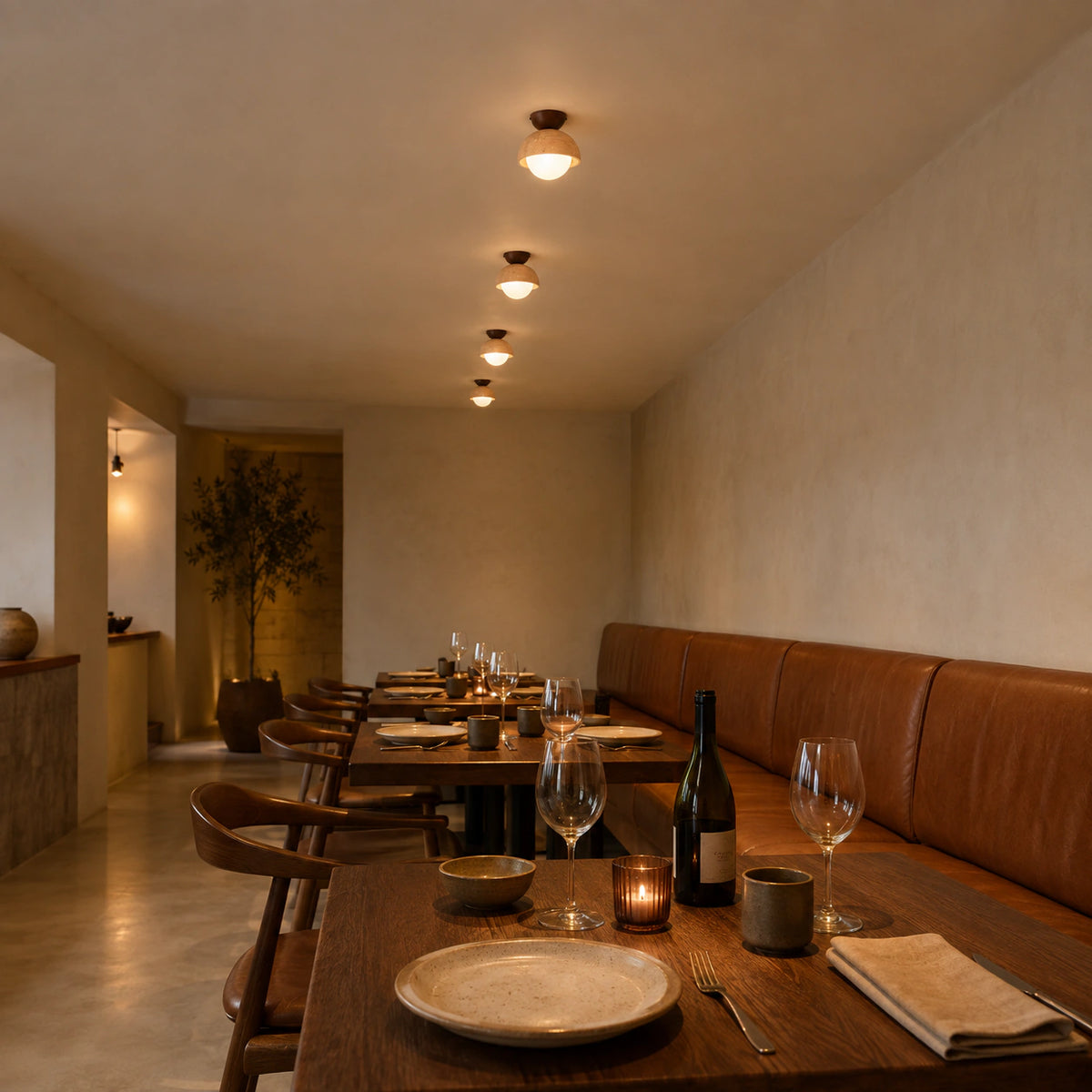 Deep travertine dome ceiling light above leather banquette seating in a restaurant