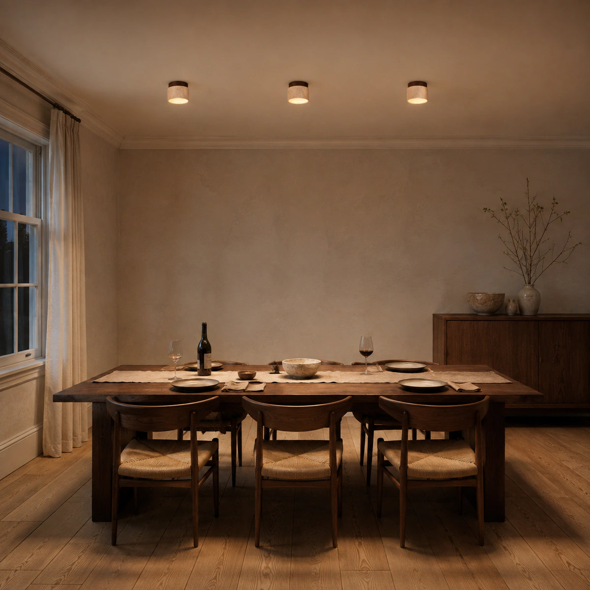 Travertine drum ceiling light lighting a minimalist dining room