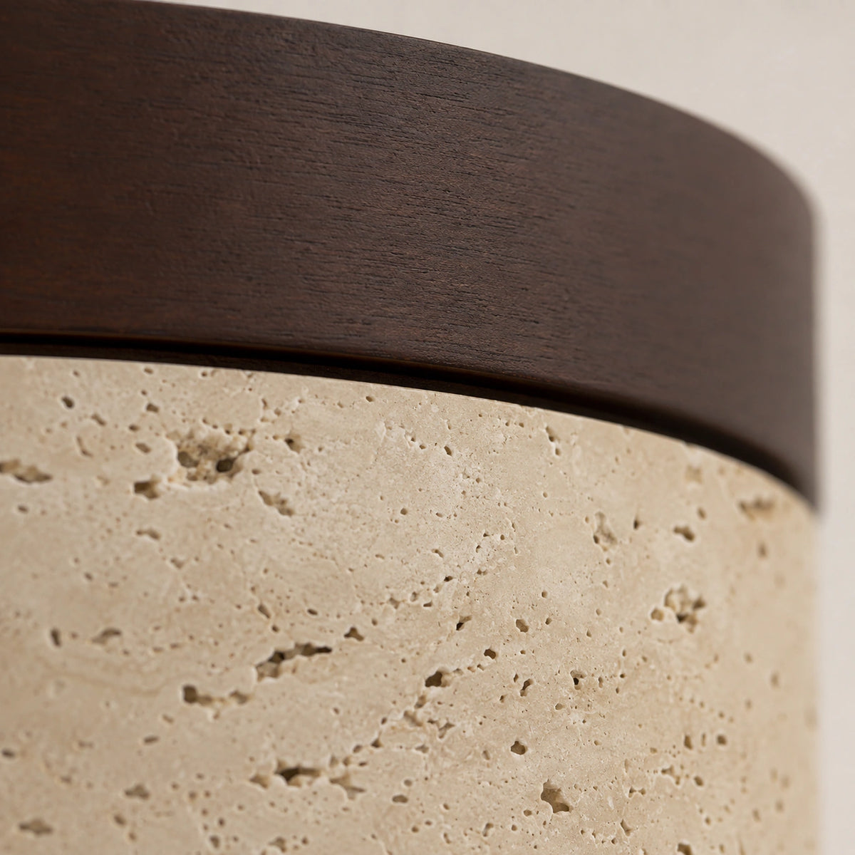Close-up of the travertine grain against the walnut band