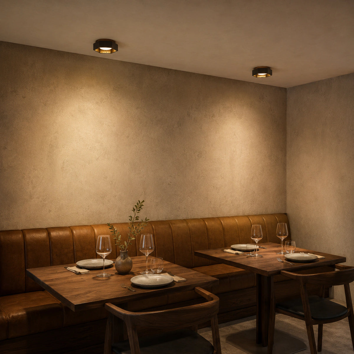 Black travertine hexagonal ceiling light above leather banquette seating in a restaurant