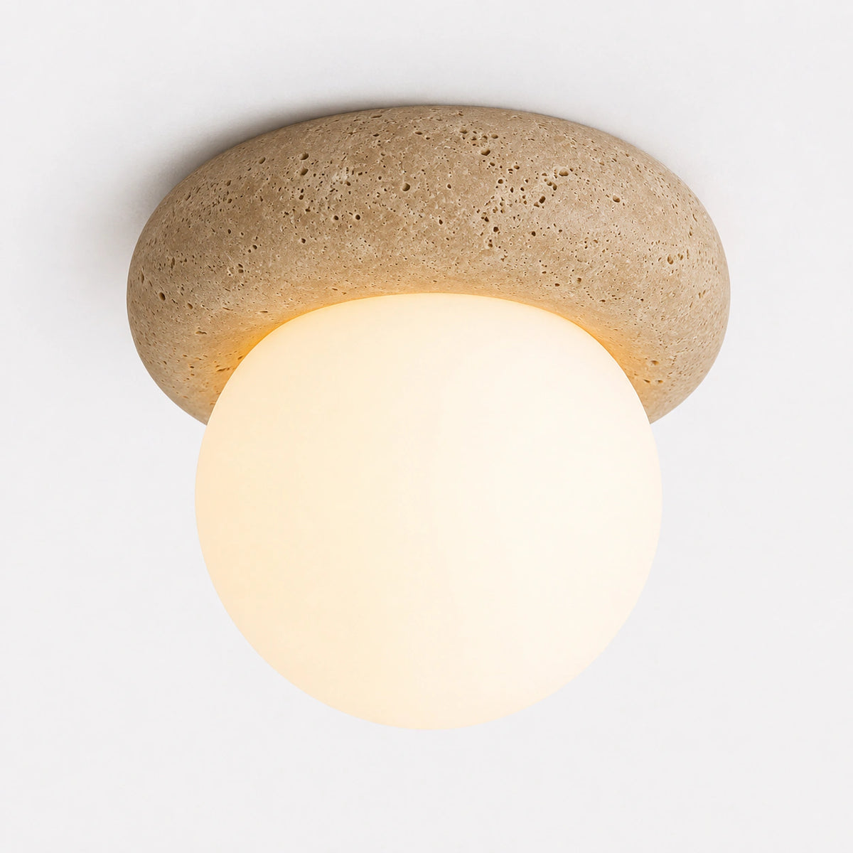 Travertine pebble ceiling light with a large opal globe on a white background