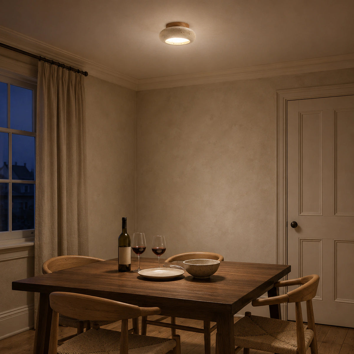 Travertine pebble flush ceiling light above a minimalist dining table