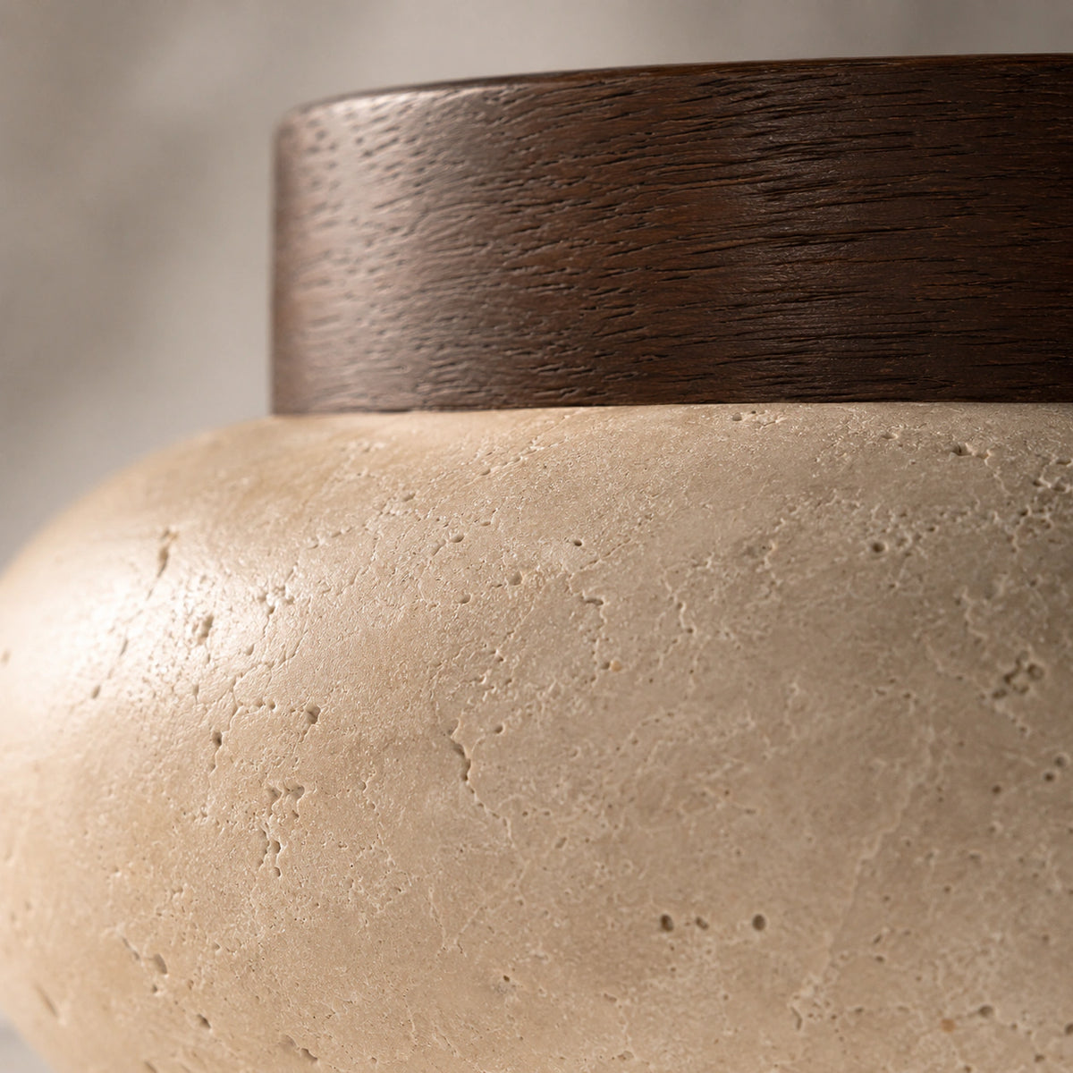 Close-up of the travertine grain on the walnut version of the pebble flush ceiling light
