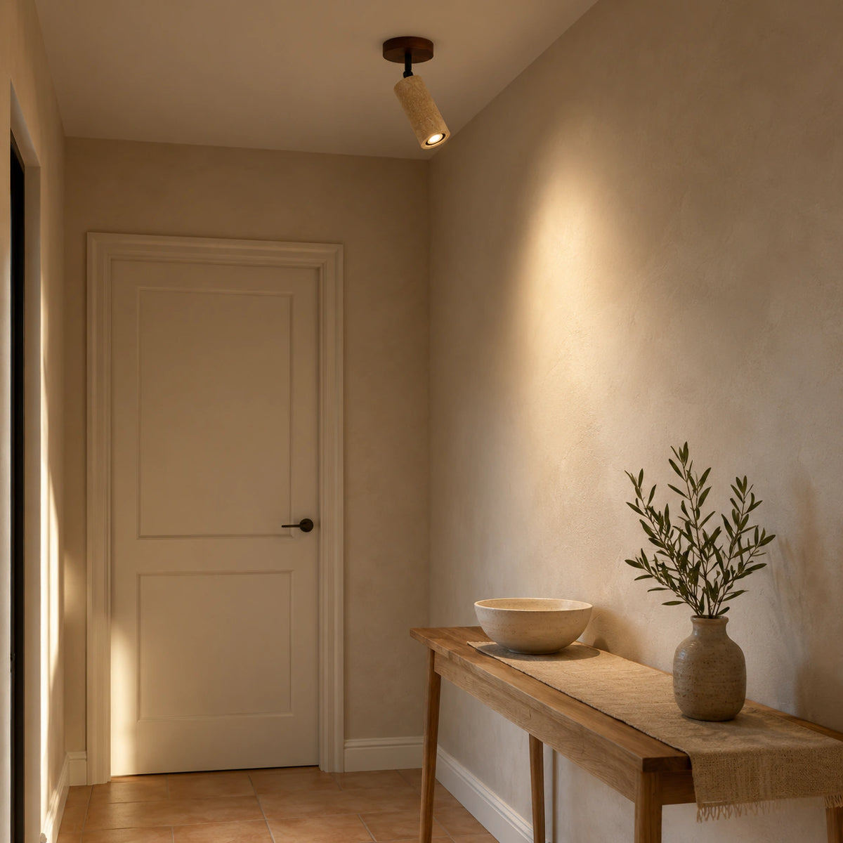 Travertine adjustable ceiling spotlight lighting a plastered hallway
