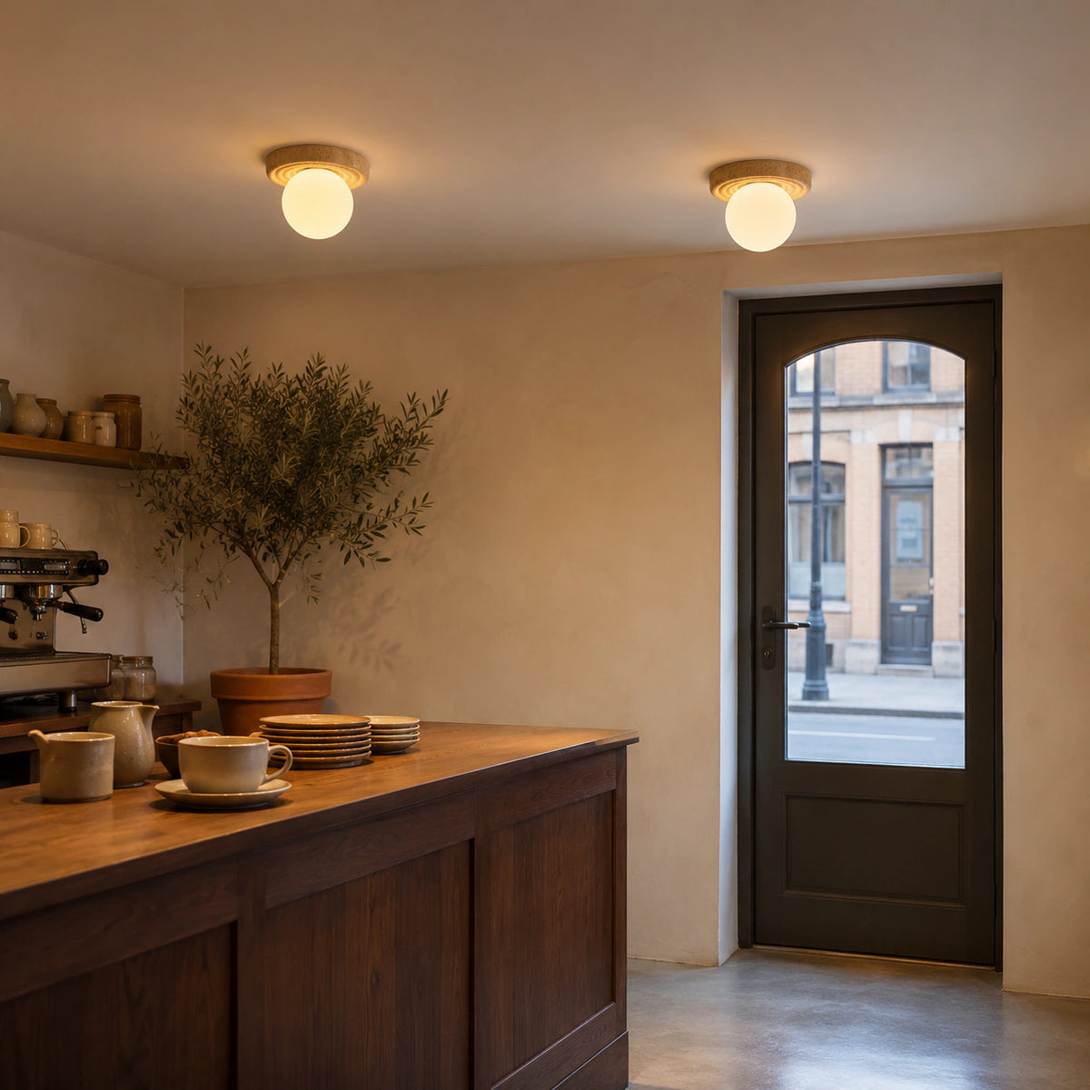 Stepped travertine ceiling light over the counter of a warm minimalist cafe