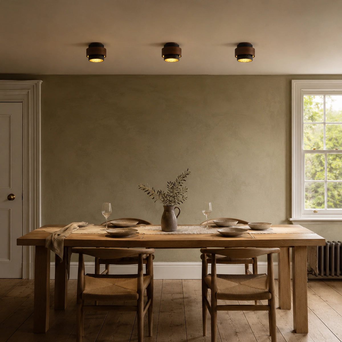 Black travertine tiered ceiling light lighting a minimalist dining room