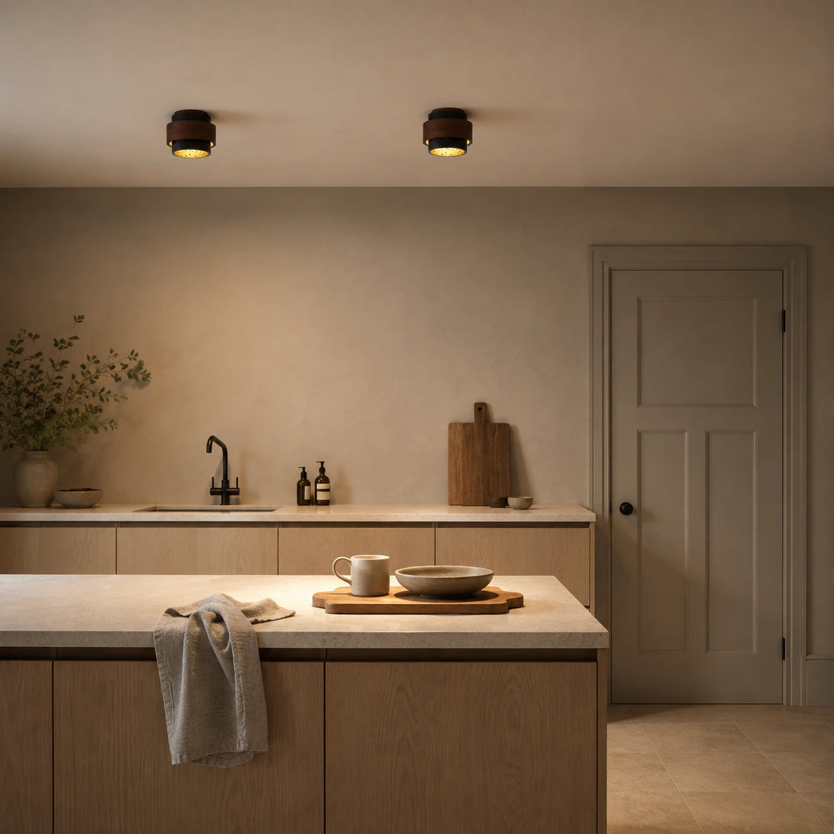 Black travertine tiered ceiling light in a warm oak kitchen