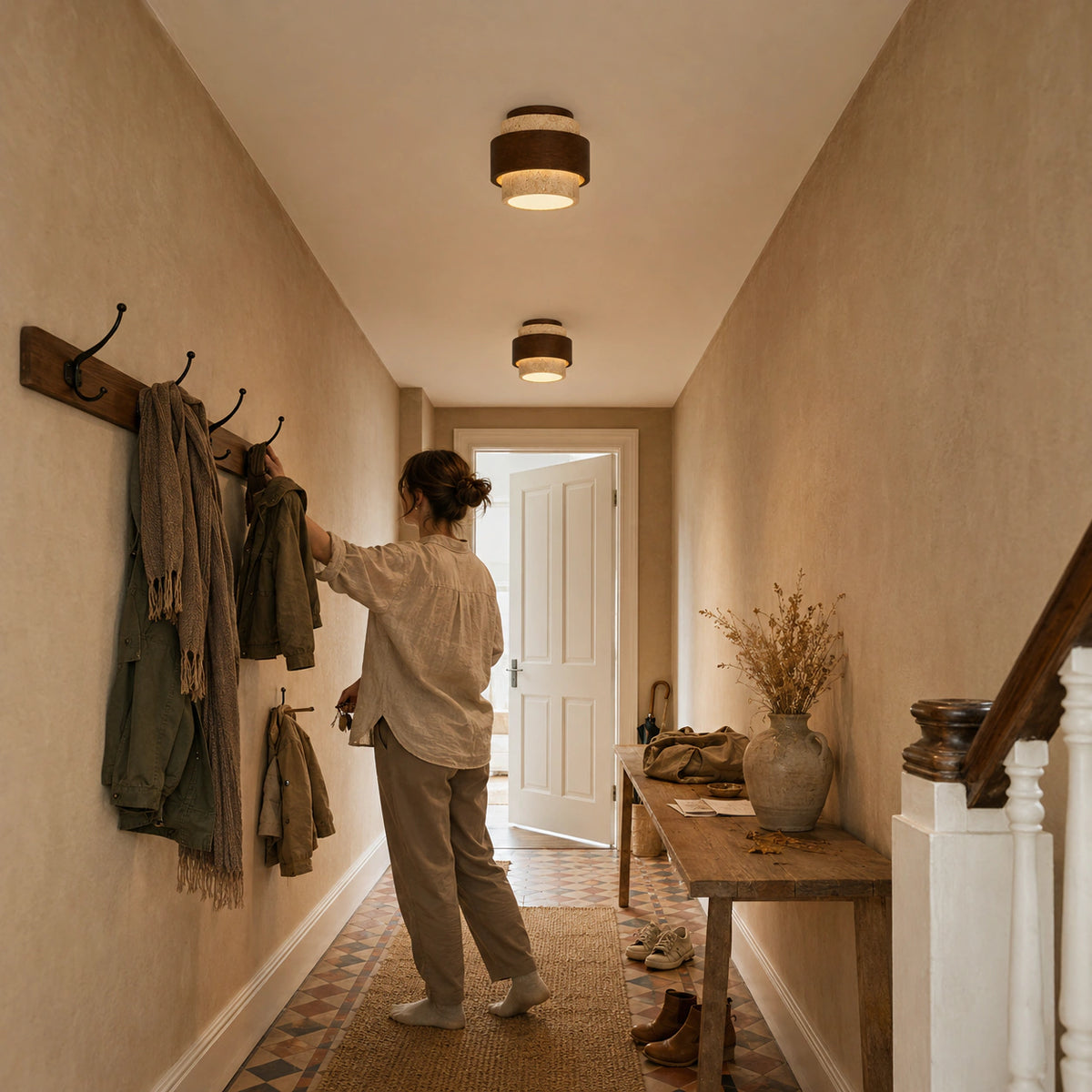 Two travertine flush ceiling lights lighting a hallway with a coat rack