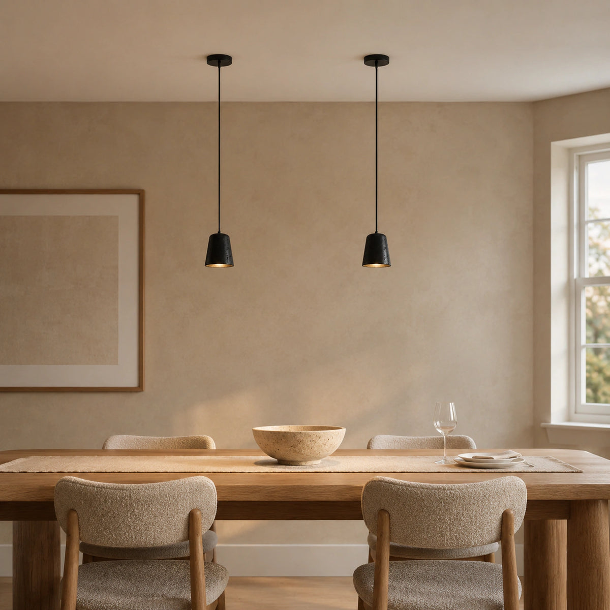 Ashby black travertine bell pendants above a dining table in a minimalist dining room