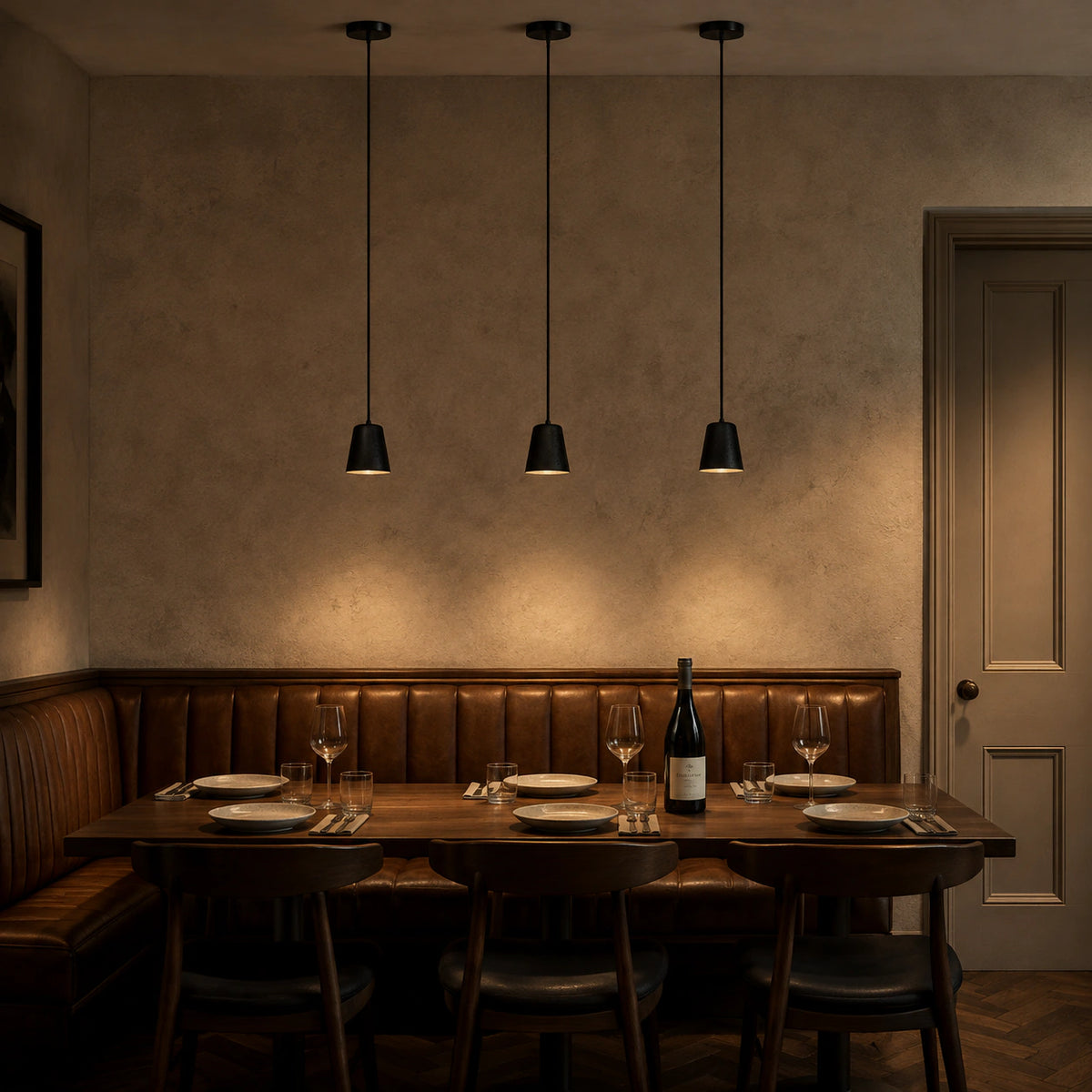 Ashby black travertine bell pendants above a restaurant table with banquette seating