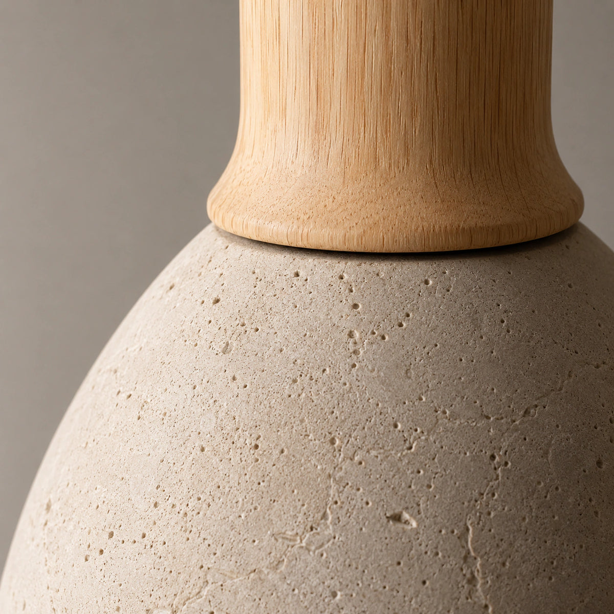 Close-up of the travertine pores and oak neck on the Wickham bell pendant