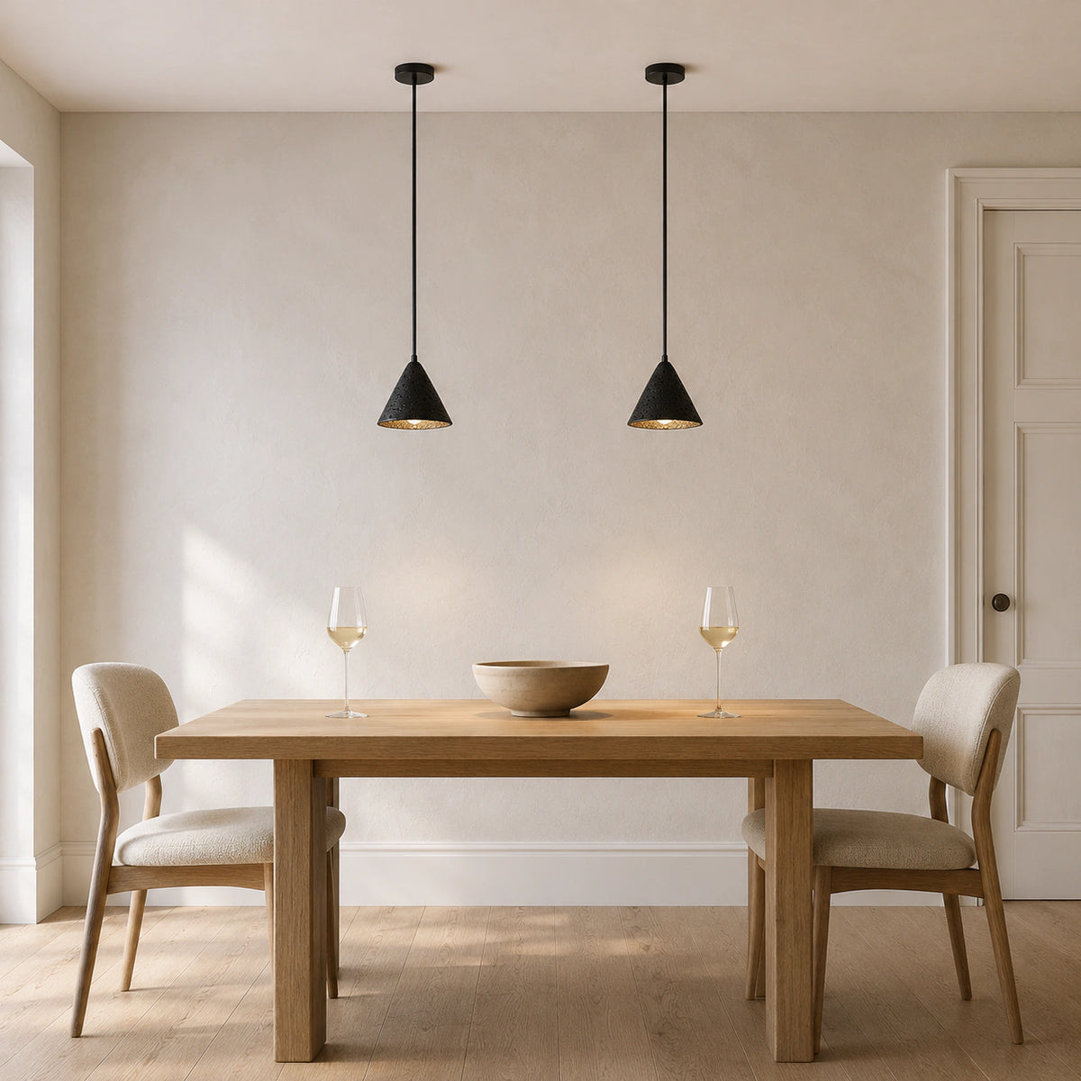 Skye cone pendant in black travertine above a dining table in a minimalist dining room
