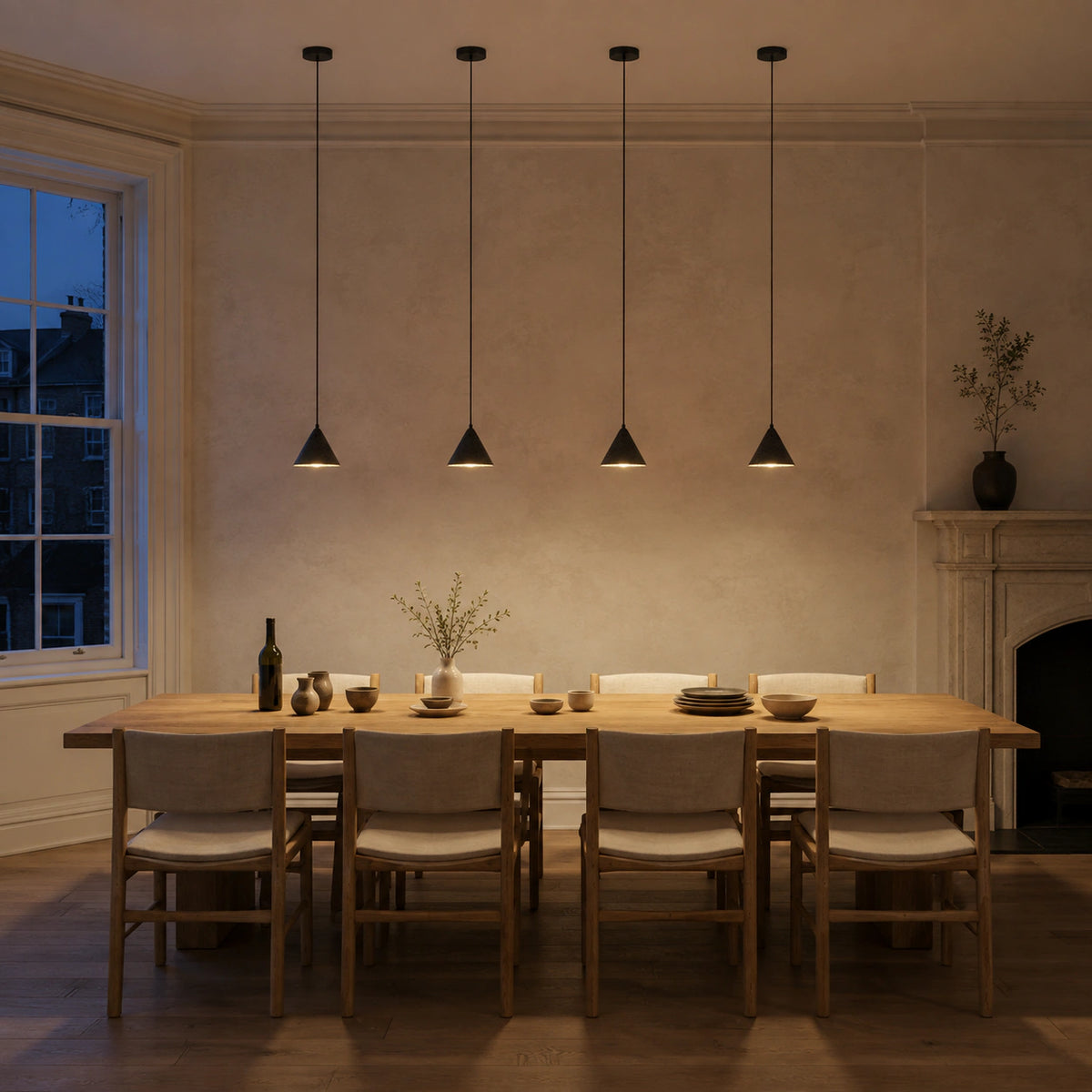 Skye cone pendants in black travertine hung in a pair above a dining table