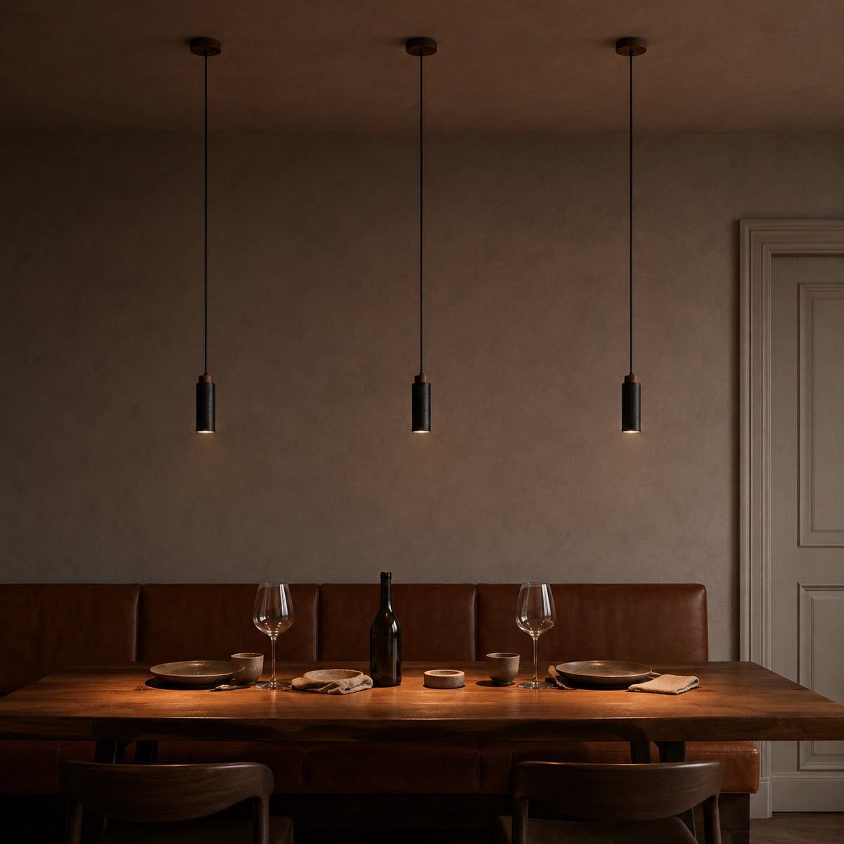 Otley pendants in black travertine above a restaurant table with banquette seating