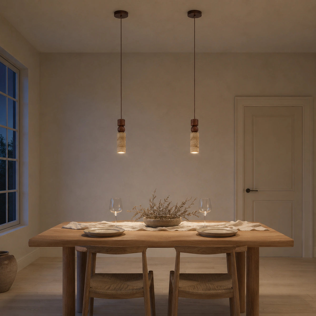 Winster travertine cylinder pendant hanging above a dining table in a minimalist dining room