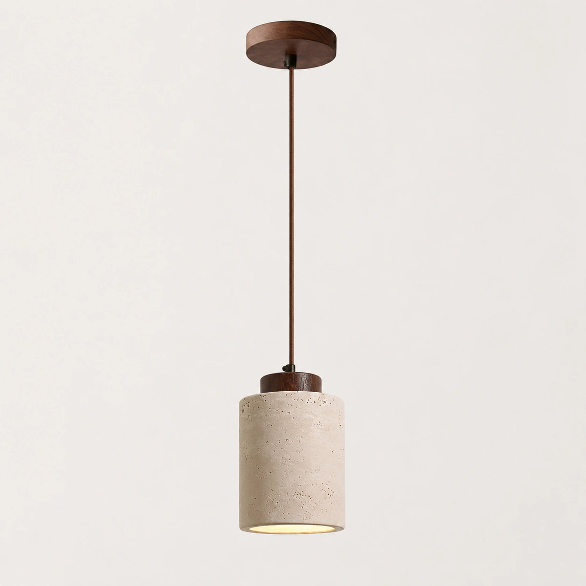 Travertine cylinder pendant light with a walnut collar on a white background