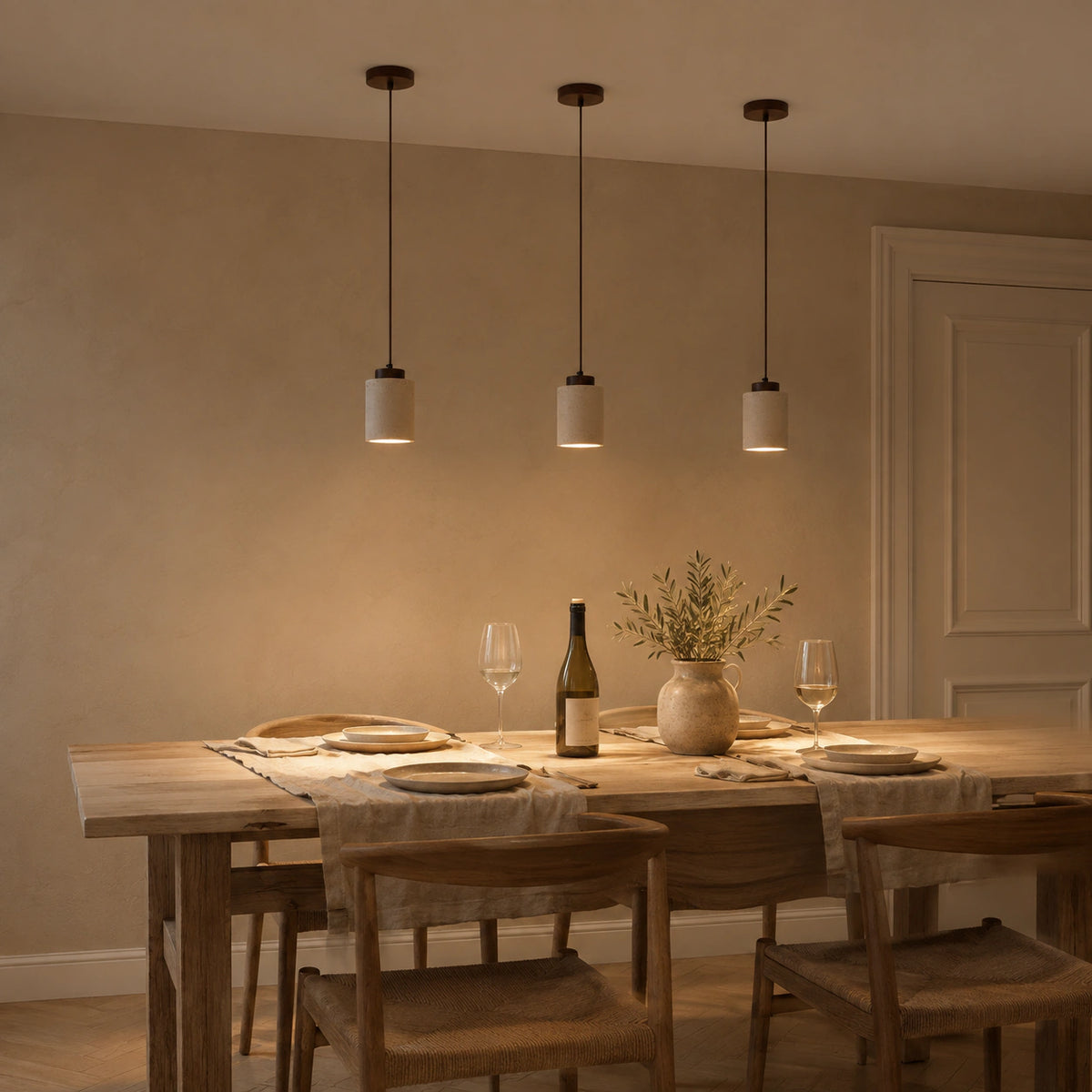 Fairlie travertine cylinder pendant in walnut above a dining table in a minimalist dining room