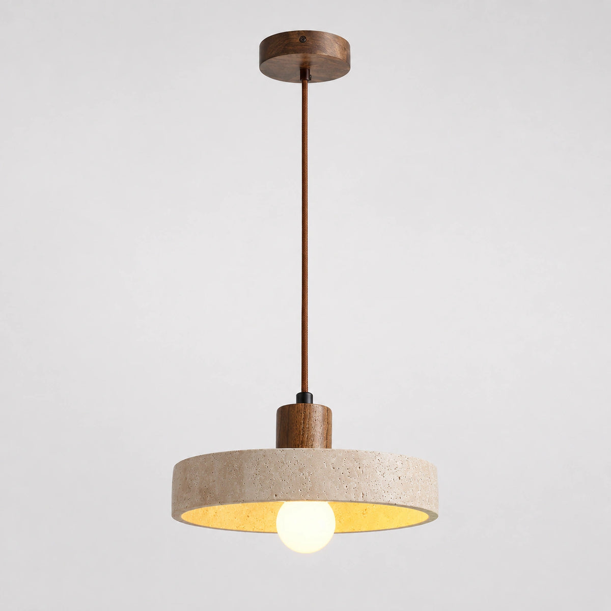 Wide travertine disc pendant light with a walnut collar on a white background
