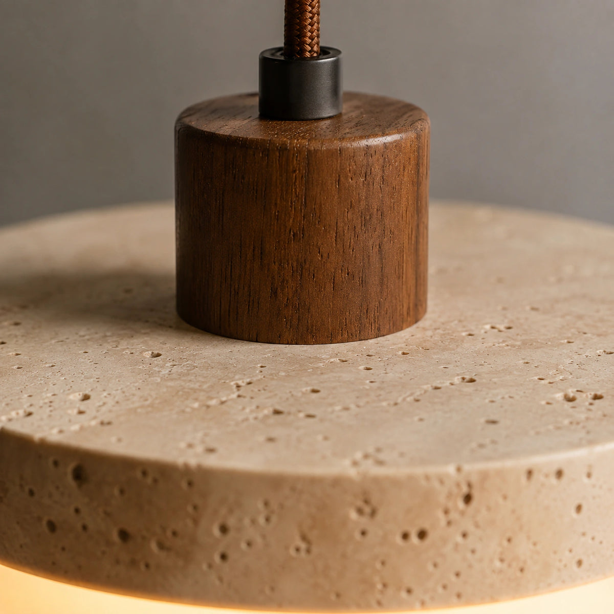 Close-up of the travertine surface and walnut collar on the Salcombe disc pendant