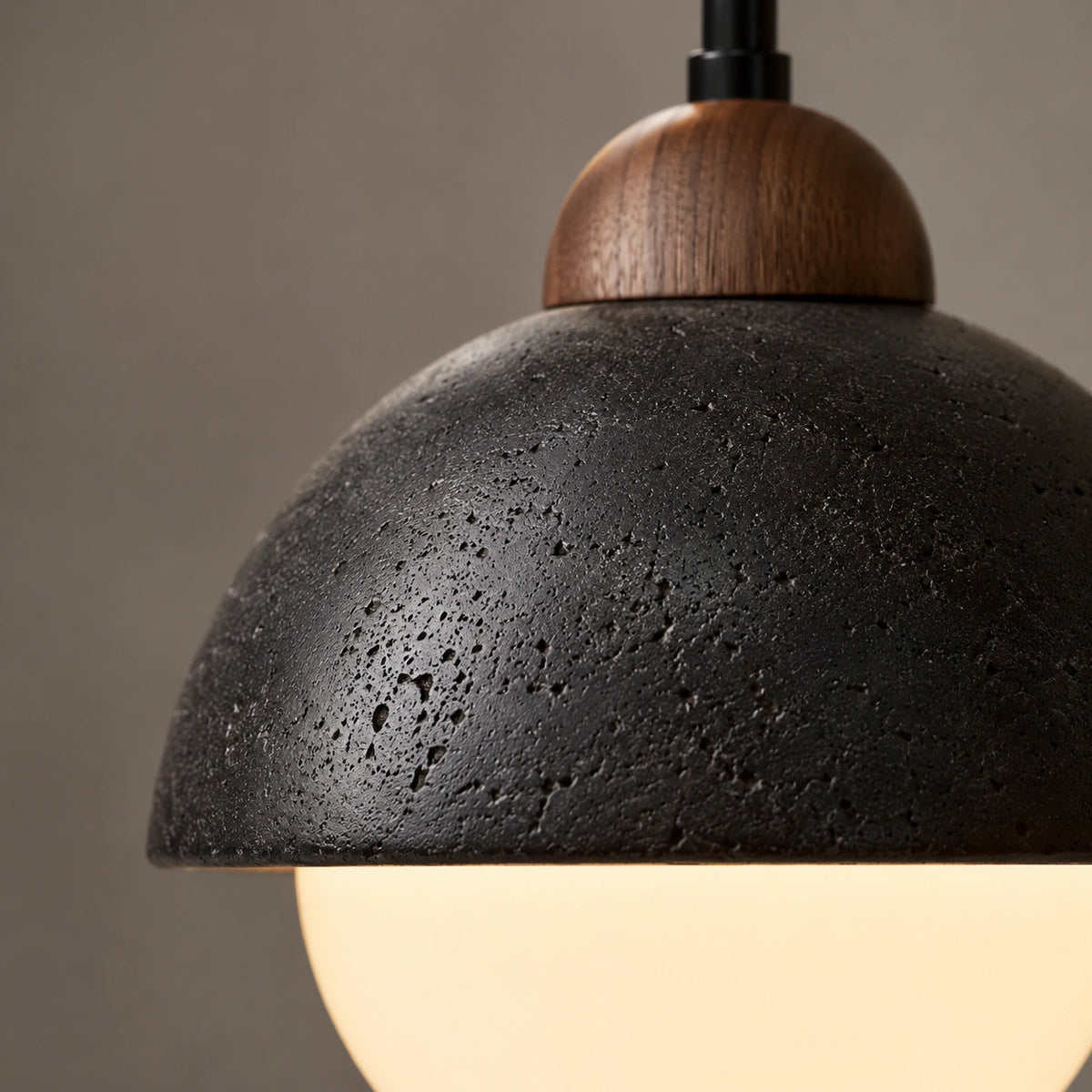 Close-up of the pitted black travertine cap and opal globe on the Malvern pendant