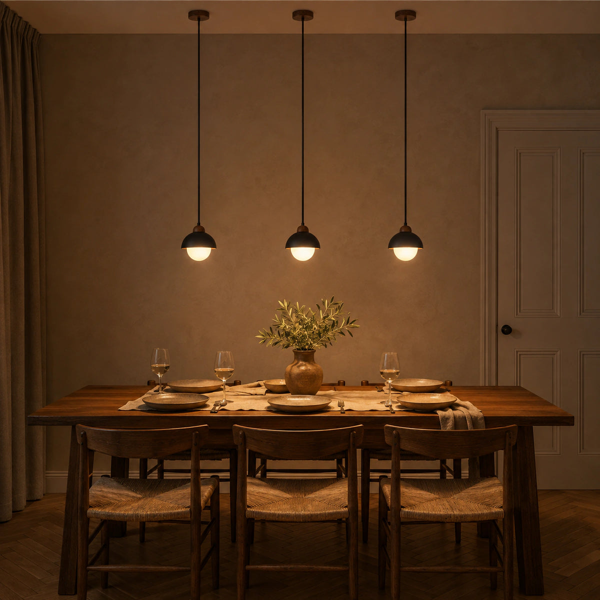 Malvern black travertine dome and globe pendant above a dining table in a minimalist room