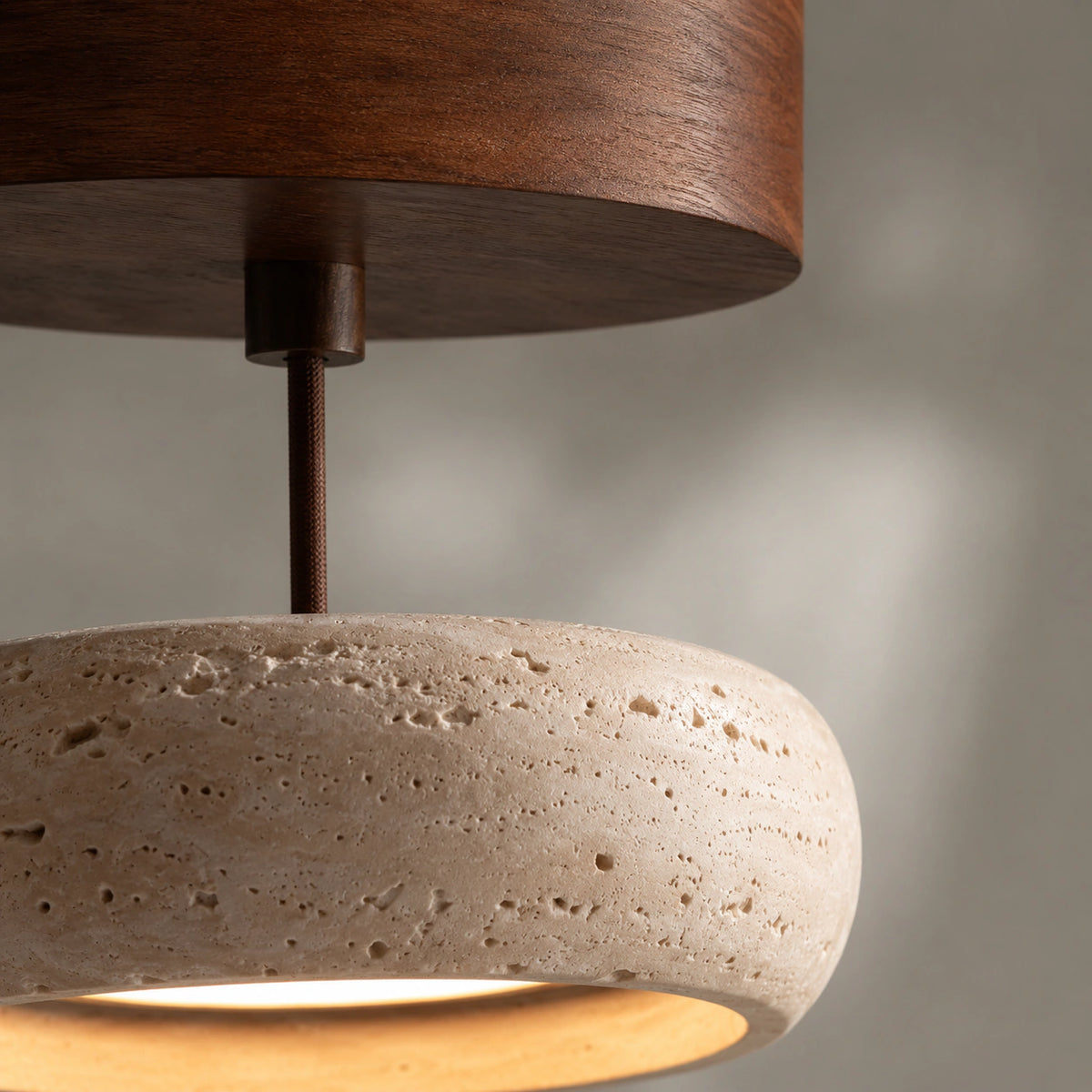 Close-up of the travertine grain wrapping the rounded pendant shade