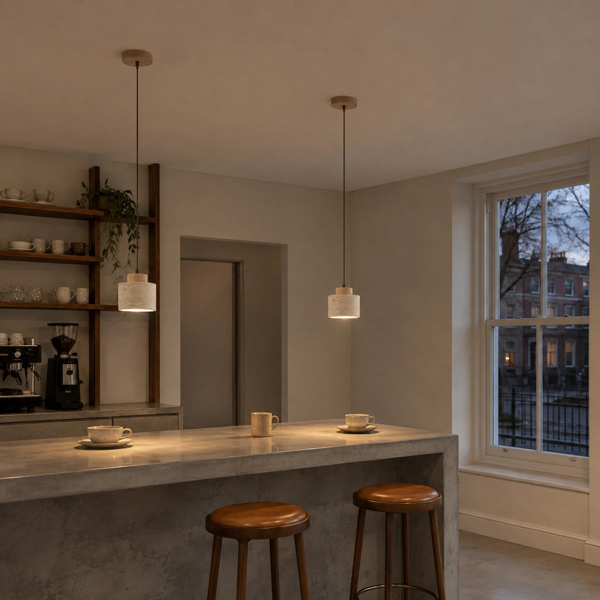 Whitby travertine drum pendant in oak above the counter of a warm, minimalist cafe
