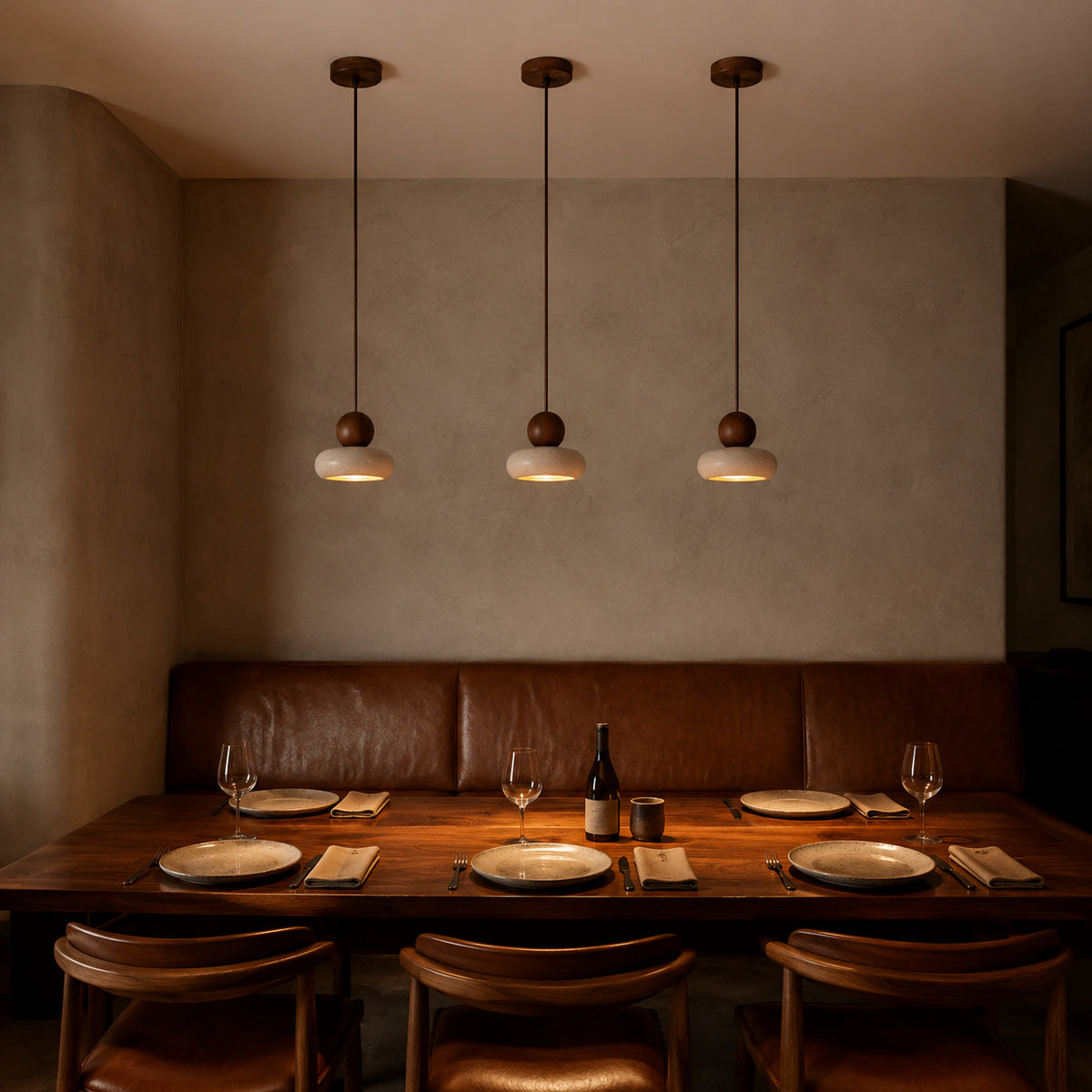 Travertine pebble pendant above leather banquette seating in a restaurant