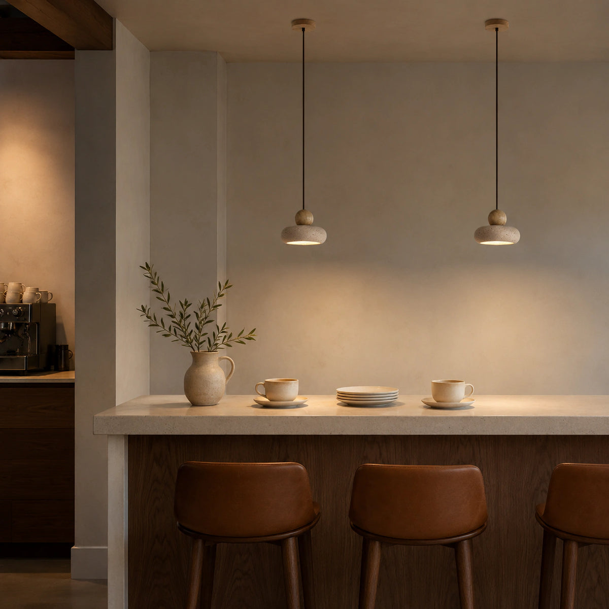 Travertine pebble pendant hanging in a warm oak kitchen