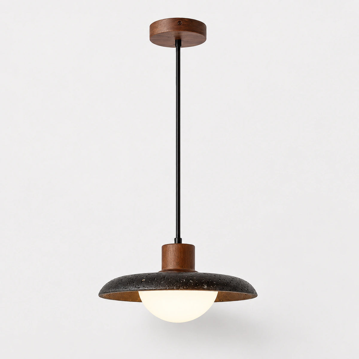 Black travertine saucer pendant light with an opal glass globe on a white background