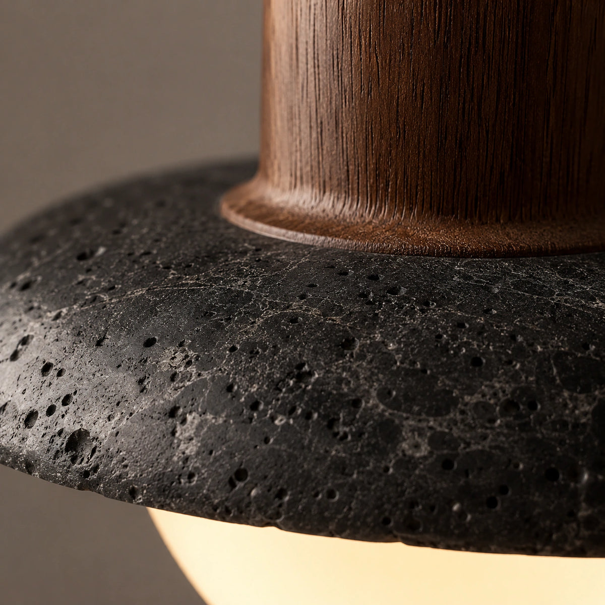 Close-up of the black travertine surface and opal globe on the Halden saucer pendant