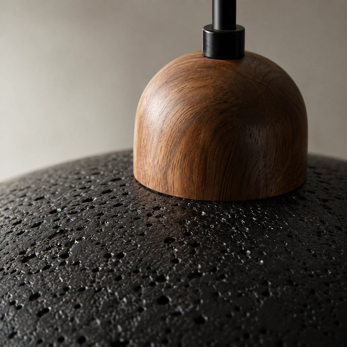 Close-up of the black travertine surface and wood lining on the Marsden saucer pendant