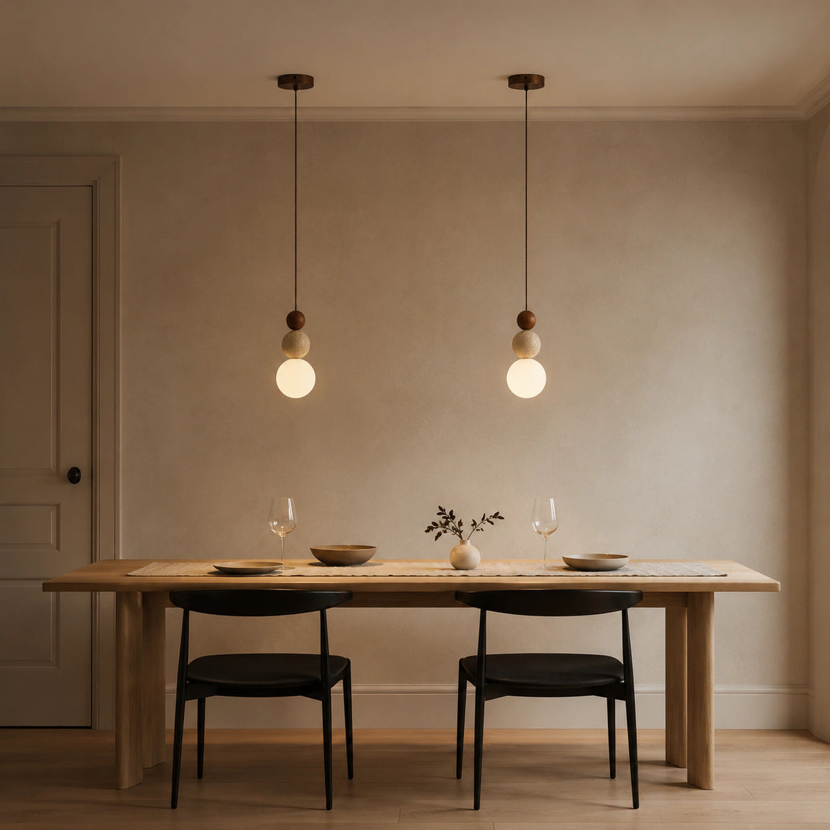 Sudbury travertine sphere pendant in walnut above a dining table in a minimalist dining room