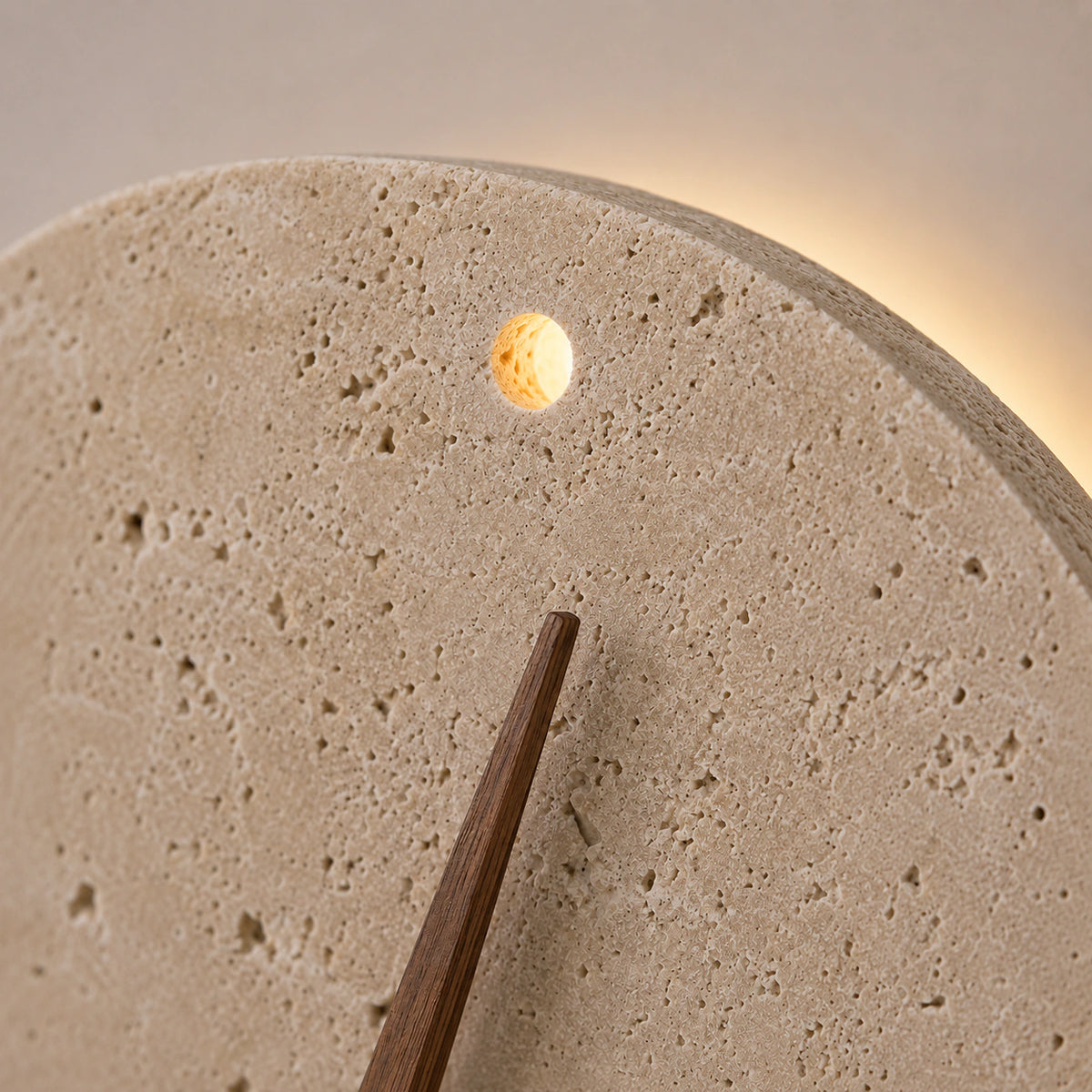 Close-up of the walnut hands and brass spindle on the Cranmore travertine wall clock