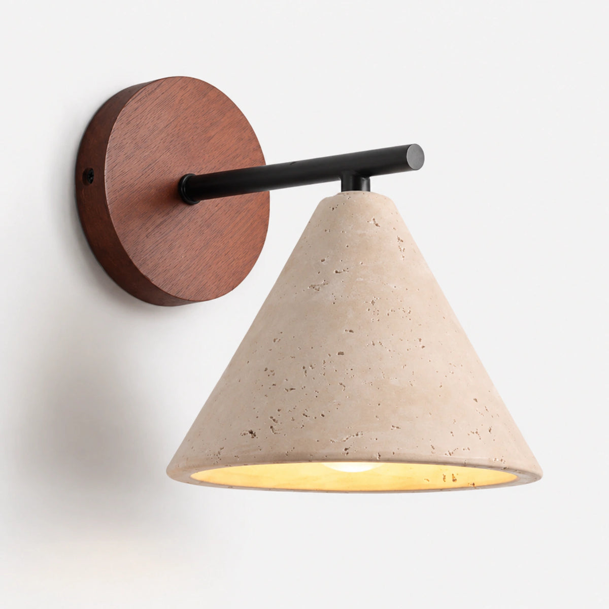 Cream travertine cone wall light on a black arm and round wood wall plate