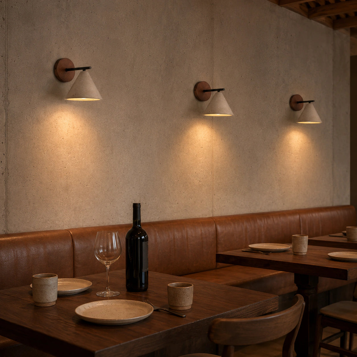 Padstow travertine cone wall lights above a restaurant banquette