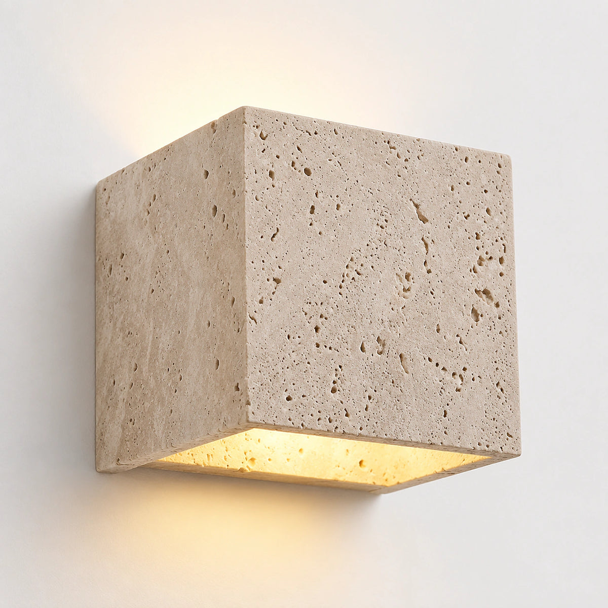 Cream travertine cube wall light throwing light up and down a white wall