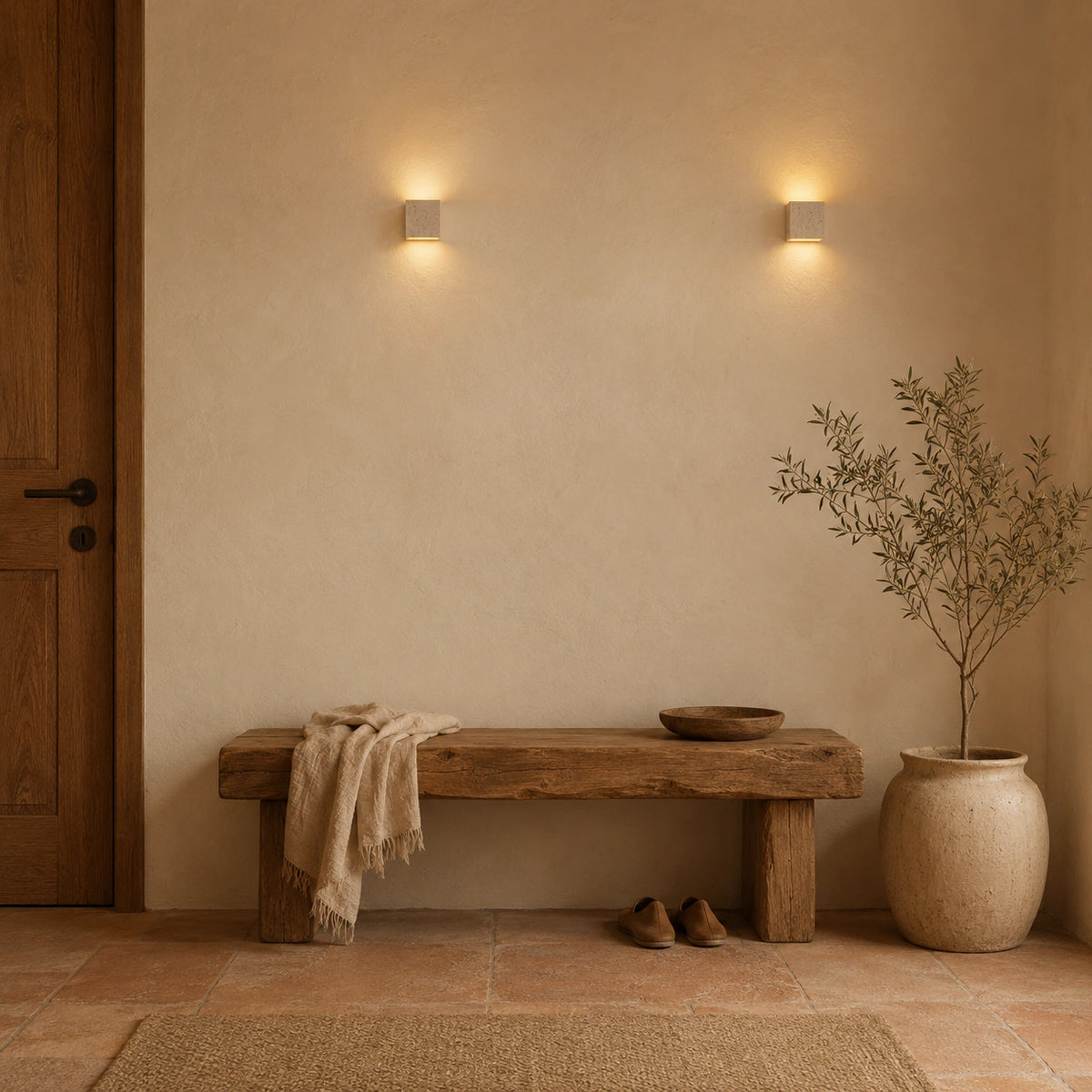 Melbury travertine cube wall light grazing light across a plastered hallway wall