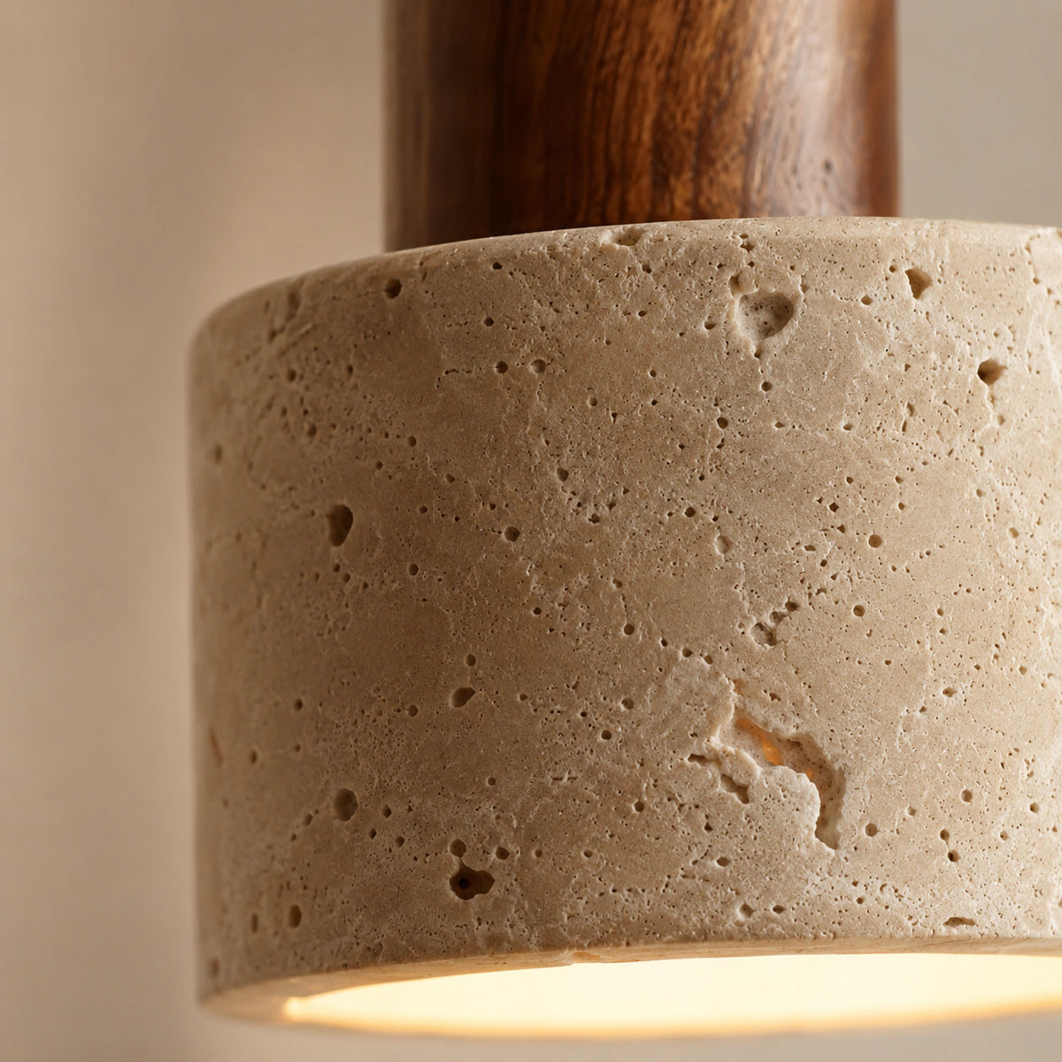 Close-up of the beige travertine grain and walnut collar on the Harlyn wall light